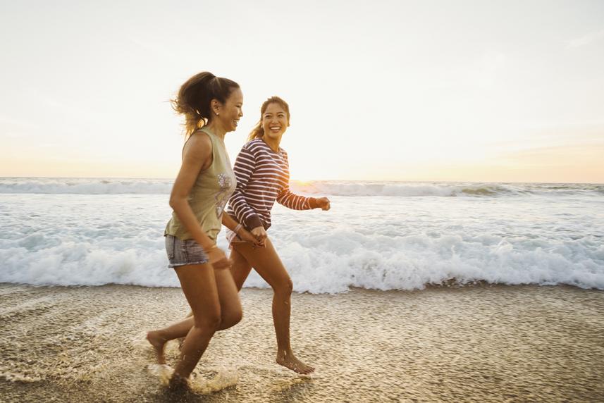 Two women running on the beach
