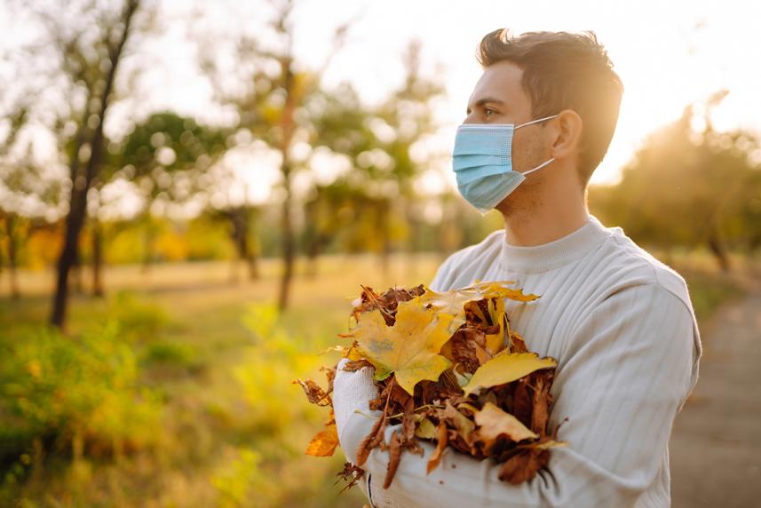 Man with face covering holding leaves