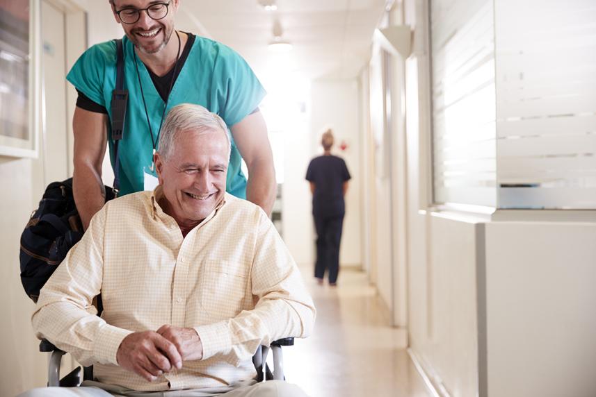 Man in hospital being pushed in wheelchair