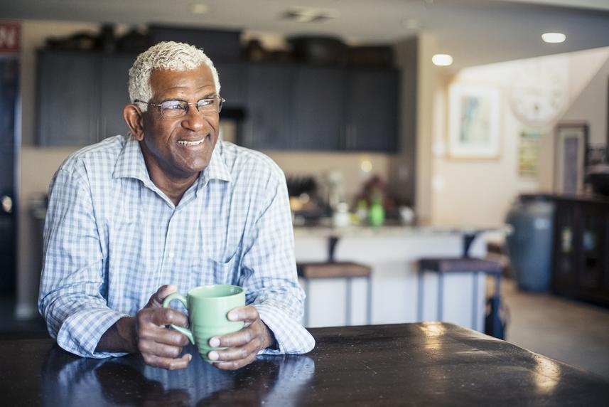 Man at table drinking from coffee mug