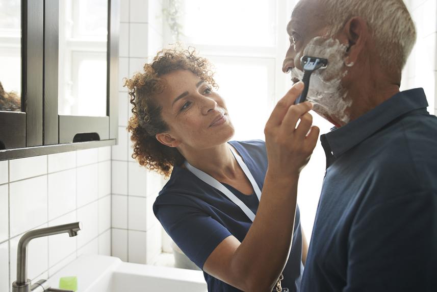 Home health aid helping with shaving