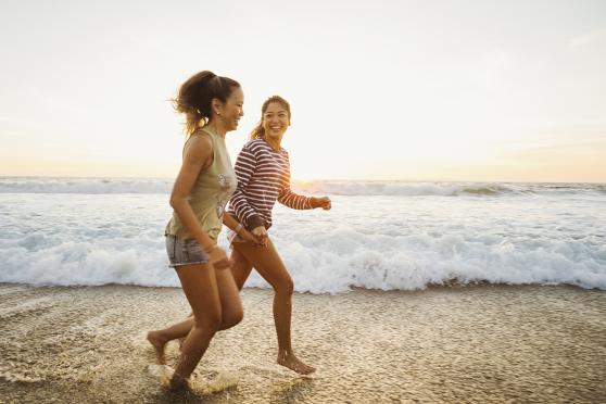 Two women running on the beach