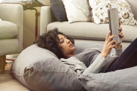 Woman lying on pillow reading