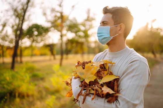 Man with face covering holding leaves