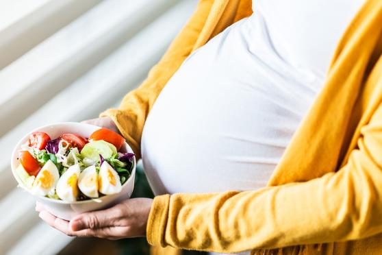 Pregnant woman holding a salad
