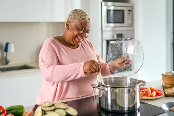 Woman in kitchen stirring a pot