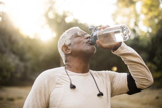 Man exercising and drinking water outdoors
