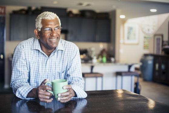 Man at table drinking from coffee mug