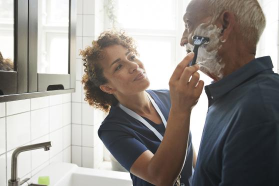 Home health aid helping with shaving